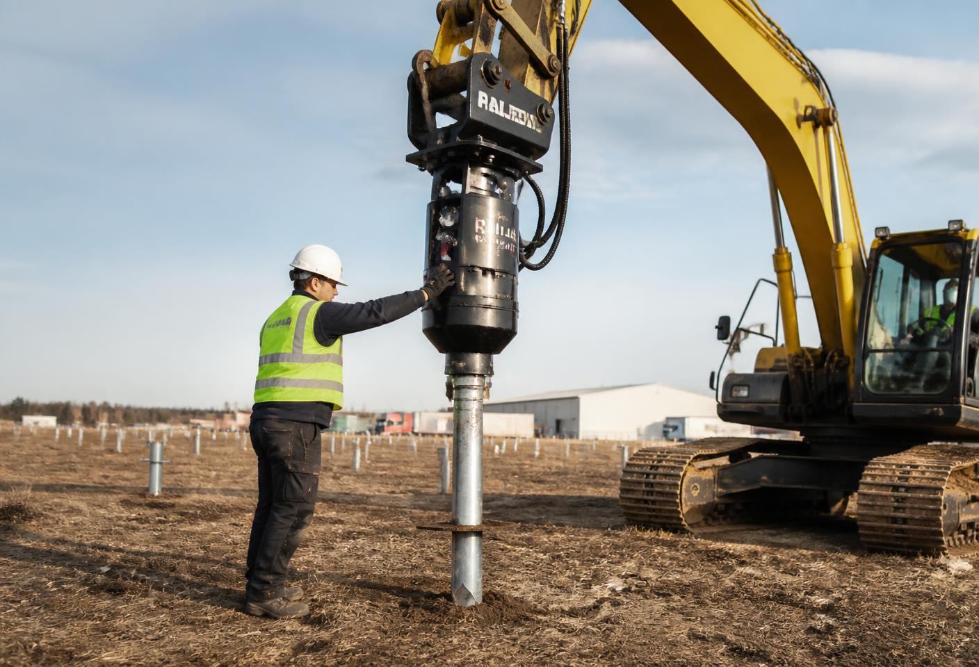 Helical pile being installed with a hydraulic drive head on a residential jobsite